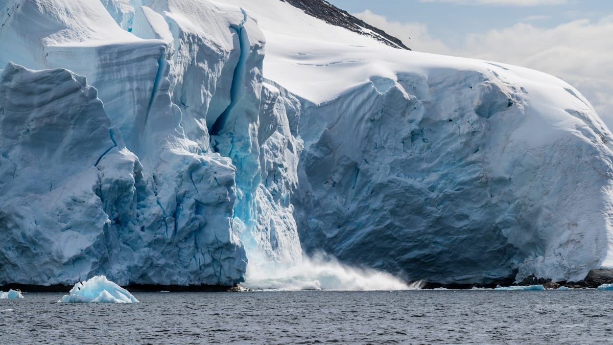 Giant chunk of ice calving off an ice sheet signifying climate change